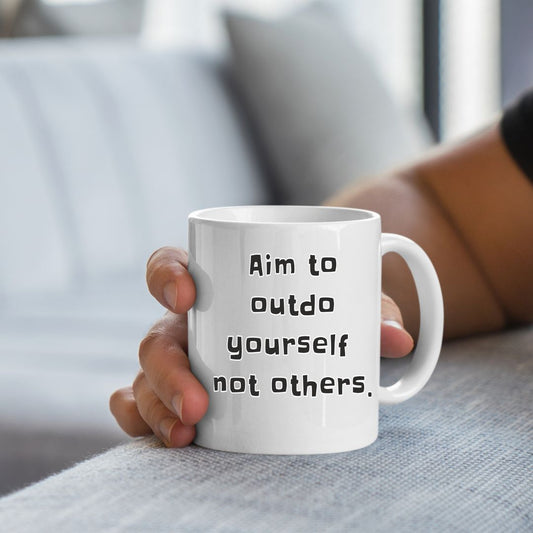 Black ceramic mug with the inspiring quote "Aim to Outdo Yourself, Not Others" – perfect for coffee, tea, or any hot beverage.